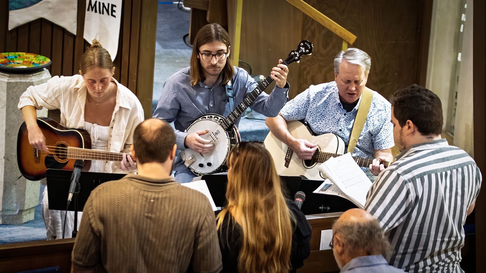 Musicians leading worship with guitar and banjo