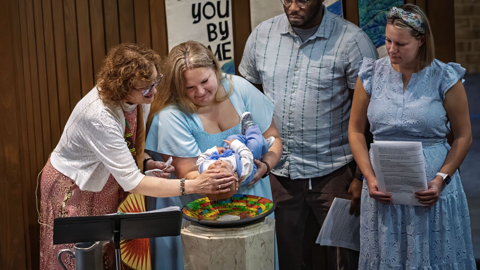 A baby is baptized at the font
