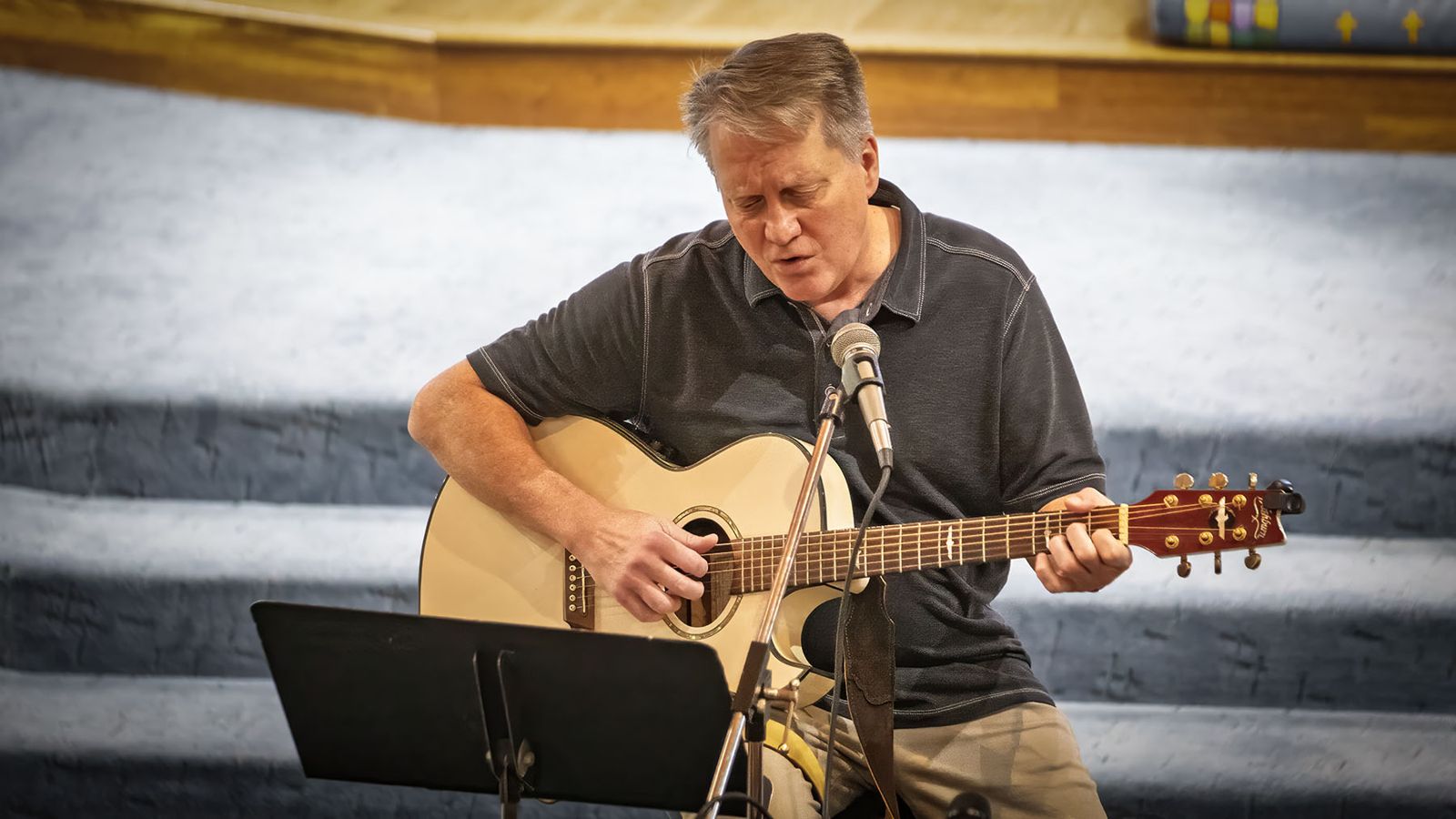 A guitarist leading a song in worship